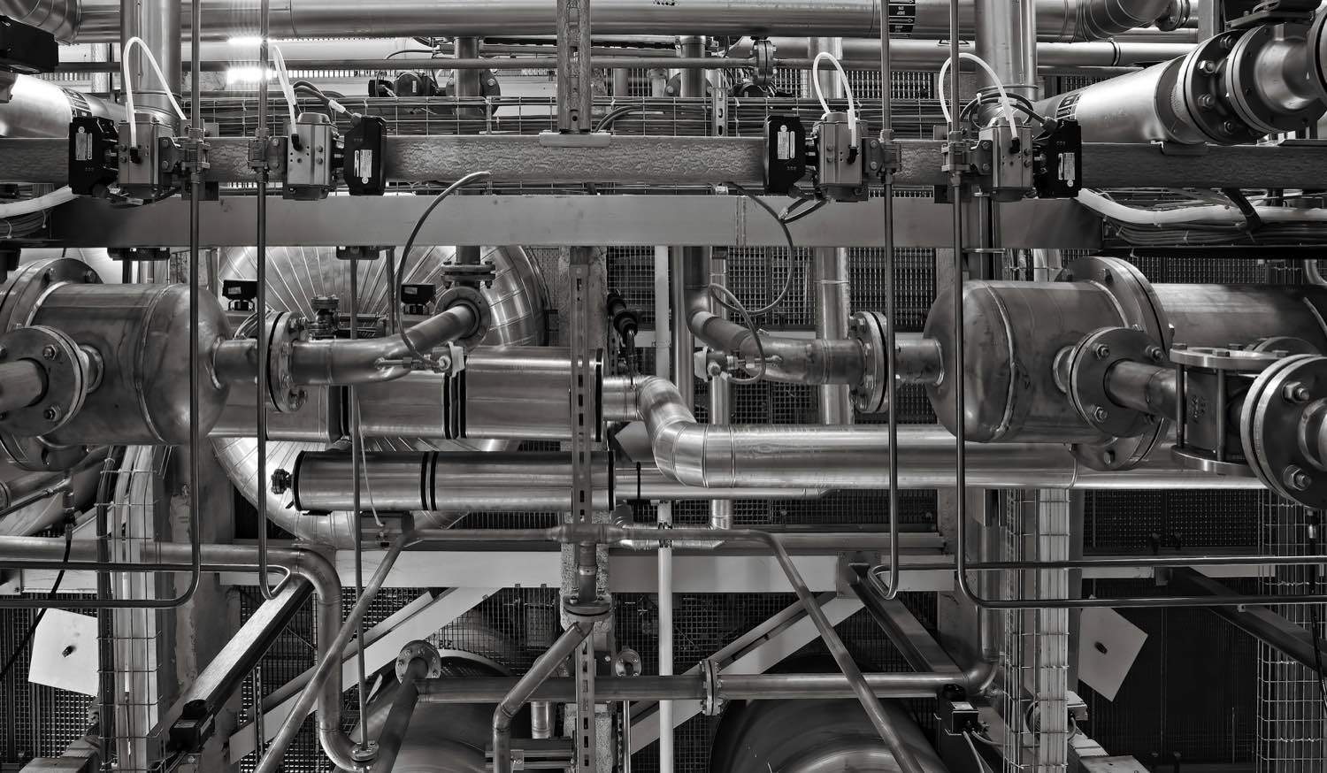 Pipework, valves and cable containment in a building plant room.